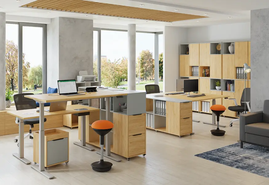 Moderní světlá open-space kancelář vybavená výškově stavitelnými stoly, ergonomickými židlemi a dřevěnými úložnými prostory.